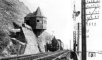 38 1772 (Bw Mainz Hbf) passiert mit P 1272 die wie ein Vogelnest an der Felswand hängende Blockstelle Kammereck, etwa 600 Meter südlich des gleichnamigen Tunnels zwischen St Goar (damalige Schreibweise ohne Punkt) und Oberwesel bei Strecken-km 129. Interessant ist der Umstand, dass Carl Bellingrodt bei seinem Foto den kompletten Hintergrund der rechten Rheinseite wegretuschierte. Auslöser war wohl, dass das Bild gar nicht den Weg ins Archiv finden sollte, weil rechts die Platte beschädigt worden war. Diese Beschädigung ließ sich nur durch eine Retusche beheben.  (17.09.1932) <i>Foto: DLA Darmstadt (Bellingrodt)</i>