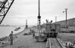 Am Rheinbahnhof in Beuel besaß die Rhein-Sieg-Eisenbahn ausgedehnte Rangier- und Aufstellgleise mit einer Länge von rund 1200 m. Dort gab es auch zwei Kräne, die die Basaltsteinverladung auf die Rheinschiffe organisierten. In Beuel war auch ständig eine Rangierlok stationiert (an diesem Tag die V 3, die sich rechts hinter dem Mast versteckt).  (14.04.1961) <i>Foto: Gerhard Karl</i>