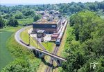 01 0509 erreicht mit ihrem Sonderzug aus Leipzig den Bahnhof Putbus. Am Zugschluss läuft 218 055 (ex 218 458) der PRESS mit. Der Zug fährt soeben an der im Mai 2024 neu eröffneten Betriebswerkstatt der Rügenschen BäderBahn (RüBB) vorbei. Über die Brücke im Vordergrund führte früher das Schmalspurgleis nach Altefähr. (14.06.2025) <i>Foto: Joachim Schmidt</i>