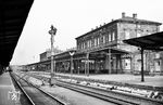 Blick auf das Empfangsgebäude des Hofer Hauptbahnhofs. Das 1874-1880 errichtete Bauwerk teilten sich einst die Bahnverwaltungen der Königlich Bayerischen Staatsbahnen und der Königlich Sächsischen Staatseisenbahn. Nach 1945 wurde Hof Grenzbahnhof zum anderen Teil Deutschlands, nach dem Ende der DDR seit 1990 wieder Durchgangsstation. Interessant ist auch das alte bayerische Ruhesignal, das in dieser Stellung "HpRu" – bei Dunkelheit mit blauem Kennlicht – anzeigt, dass auf dieser Gleisverbindung der Zugverkehr ruht, Rangierfahrten aber weiterhin erlaubt sind. (31.07.1963) <i>Foto: Karl-Ernst Maedel</i>
