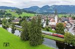 218 421 mit IC 2084 nach Augsburg (- Hamburg-Altona) zwischen Iller und Pfarrkirche St. Verena in Fischen. (04.08.2025) <i>Foto: Joachim Schmidt</i>