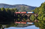 185 518 von Alpha Trains Luxembourg mit DGS 56433 (Kreuztal - Dortmund-Obereving) auf der Lennebrücke bei Werdohl. Bei genauerem Hinsehen offenbart sich auch der Grund der vielen Brückenschäden auf der Ruhr-Sieg-Strecke. Diese entstanden, weil es die DB seit vielen Jahren versäumt hat, die teils meterhoch gewachsenen Bäume aus den seitlichen Brückengewölben zu entfernen. (11.08.2025) <i>Foto: Joachim Bügel</i>