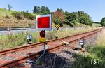 Um die Weiterfahrt zur maroden Ederbrücke in Richtung Bad Berleburg zu verhindern, wurde in km 10,4 eine Sh-Scheibe ("Schutzhalt") mit dahinter liegender Gleissperre montiert. Nach den Bestimmungen des Signalbuchs ist eine Sh2-Scheibe auf freier Strecke allerdings in mindestens 50 Metern Sicherheitsabstand vor der Stelle aufzustellen, an der Züge ausnahmsweise anhalten sollen. Die Aufstellung unmittelbar vor der Gleissperre ist also nicht regelkonform. Besonders bizarr ist zudem die Sh-Scheibe aus der Gegenrichtung, da auf der Stichstrecke während der Sperrung kein Zug aus dieser Richtung kommen kann. (11.08.2025) <i>Foto: Joachim Bügel</i>