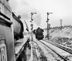 Blick aus dem Führerstand einer 23er, die aus Ansbach kommend auf Einfahrt in den Bahnhof Crailsheim wartet, während die Crailsheimer 044 558 (ex 44 1562) mit einem Militärzug in Richtung Lauda ausfährt. (03.1969) <i>Foto: Jörg Schulze</i>