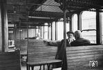 Reisende in einem Wagen der 3. Klasse, passenderweise als "Holzklasse" bezeichnet. Die Lattensitzbänke aus Eschenholz boten bis zu einem gewissen Grad einen besseren Sitzkomfort als die vandalismusresistenten Sitze in heutigen Nahverkehrszügen. (1950) <i>Foto: Kopetzky</i>