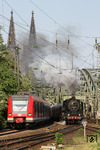 Parallelfahrt zwischen 423 043 und 01 2066, die von der Hohenzollernbrücke kommend in den Bahnhof Köln Messe/Deutz einfahren. Im Hintergrund die Turmspitzen des Kölner Doms. (01.05.2011) <i>Foto: Joachim Bügel</i>