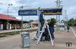Wartung von Zugzielanzeigern im Bahnhof Crailsheim. Diese Zugzielanzeiger-Variante ist digital und setzt Leuchtdioden (LED) oder Flüssigkristallbildschirme (LCD) ein. Die sogenannten Vollmatrix-Anzeiger haben den Vorteil, dass sie weniger störungsanfällig sind, Informationen durch selbstleuchtende Bildschirme lesbarer angezeigt werden können und Bildschirme nicht auf einen festgelegten Satz von Zeichen wie Fallblattanzeiger beschränkt sind. Ein Update der Software kann alle digitalen Anzeiger direkt auf den neuesten Stand bringen und erspart so die Auswechselung Tausender Registerkarten wie bei den alten analogen Anzeigern. Bei der Deutschen Bahn bestehen die Vollmatrix-Anzeiger aus mehreren dunkelblauen Bildschirmen, die von hinten durch Leuchtstoffröhren, bzw. LED bei aktuellen Geräten, beleuchtet werden. Die Anzeiger sind monochrom (dunkelblau und weiß) und vergleichsweise niedrig aufgelöst. Sie können somit keine farbigen Wagenstände anzeigen, erreichen jedoch einen hohen Kontrast und sind aufgrund der verwendeten Transflektor-Folie zwischen Hinterleuchtung und LCD-Glas auch bei direkter Sonneneinstrahlung lesbar. Die LCD-Bildschirme haben jedoch auch einige Nachteile: Die teilweise verdichteten Informationen sind oft nur unmittelbar am Anzeiger lesbar. Die langsamen Lauftexte führen zudem dazu, dass die Benachrichtigungen in Gänze nicht mehr schnell erfasst werden können. Mittlerweile tauscht die Bahn die Zugzielanzeiger gegen Farbmatrix-LED-Bildschirme mit höherer Auflösung aus, mit denen auch Farbdarstellungen möglich sind. Der Austausch aller Anzeiger wird aber noch Jahre dauern. (15.09.2025) <i>Foto: Joachim Schmidt</i>
