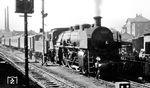 18 477 (Bw Lindau) steht vor einer Zuggarnitur in den Abstellgleisen des Bahnhofs Friedrichshafen. (08.1953) <i>Foto: Karl Wyrsch, Slg. D. Ammann</i>