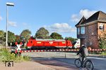 245 024 verlässt mit IC 2310 "Nordfriesland" nach Westerland (Sylt) den Bahnhof Niebüll über den Bü der Gather Landstraße. Rechts steht das Stellwerk "Nf". Dadurch, dass die Kurswagen nach Dagebüll Mole diesmal am Schluß des Zuges hingen und man sich das aufwendige Rangiermanöver mit der Zuglok ersparen konnte, reduzierte sich die Verspätung des Zuges von 42 Minuten (Ankunft Niebüll) bis auf 21 Minuten im Zielbahnhof Westerland auf Sylt. (23.09.2025) <i>Foto: Joachim Bügel</i>