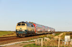218 330 schiebt den RE 11081 nach Husum am Ende des Hindenburgdamms in Höhe des Friedrich-Wilhelm-Lübke-Koogs westlich von Klanxbüll. (23.09.2025) <i>Foto: Joachim Bügel</i>
