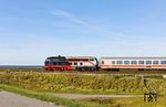 Zwei namhafte Modellbahnhersteller kreierten in einer Kooperation mit dem Werk Cottbus ein gemeinsames Modell mit der auffällig lackierten 218 497. Sie ist das Ergebnis eines Kreativwettbewerbs unter den Mitarbeitern des Fahrzeuginstandhaltungswerks Cottbus und symbolisiert die Geschichte des Werkes von der Dampflokzeit (schwarz) bis zur ICE-Zeit in grau mit rotem Band. Hier brummt die Lok vor dem IC 2310 aus Köln am Friedrich-Wilhelm-Lübke-Koog ihrem Ziel in Westerland (Sylt) entgegen. (24.09.2025) <i>Foto: Joachim Bügel</i>