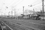 Stellungswechsel nach Saarbrücken Hbf: Dort fährt gerade die Saarbrückener 051 228 mit einem gemischten Güterzug ein. Hinter dem Zug liegt das von den Bahnsteigen gut einsehbare Bw Hbf. (05.04.1971) <i>Foto: Wolfgang Bügel</i>
