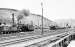 44 596 verlässt als Schiebelok an einem Güterzug den Bahnhof Altenhundem in Richtung Welschen Ennest. Im Bahnhof wartet bereits der nächste mit einer 44er bespannte Güterzug. (11.03.1956) <i>Foto: Carl Bellingrodt</i>