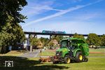 Während ein überdimensionaler Rasenmäher auf dem Platz des Fussballclubs Borussia 93 Rendsburg für den perfekten Rasen sorgt, fährt still und leise ein 526 der Nordbahn über die Rendsburger Hochbrücke. (10.09.2025) <i>Foto: Thorsten Eichhorn</i>