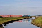 212 212 mit den DB-Doppelstockwagenzug RE 11004 nach Westerland (Sylt), bestehend aus den Wagen 36-75 086-9 + 26-75 085-3 + 26-75 088-7 + 26-75 087-9 + 86-81 034-0, am Soholmer Au-Kanal zwischen Langenhorn und Stedesand. (02.10.2025) <i>Foto: Zeno Pillmann</i>