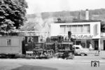 Da der Zug entlang der Hauptstraße in Mosbach (Baden) unter anhaltendem Läuten nur in Schrittgeschwindigkeit unterwegs war, konnte man ihn sogar problemlos zu Fuß überholen. An der Milch-Trinkstube unmittelbar vor dem Bahnübergang zur Eisenbahnstraße (vgl. Bild-Nr. 112977) kann er langsam Fahrt aufnehmen. (05.1959) <i>Foto: Jürgen Hagemann, Slg. R. Garn</i>