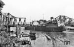 Die britische "CORSOUND" an der geöffneten Drehbrücke des Nord-Ostsee-Kanals in Rendsburg. Die steigende Zahl von Schiffsbewegungen führte Ende der 1950er Jahre zu immer längeren Staus vor der Brücke. Am 24. Juli 1961 wurde sie stillgelegt und am 25. Juli 1961 für den Autoverkehr der Kanaltunnel Rendsburg im Zuge der Bundesstraße 77 eröffnet. Für Fußgänger folgte 1965 ein Fußgängertunnel. (1955) <i>Foto: Slg. Thorsten Eichhorn</i>