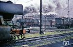 Ruhrgebietsatmosphäre in Oberhausen-Osterfeld Süd. Am Bahnbetriebswerk dampft 052 483 an der dort wartenden 191 010 vorbei. (08.1970) <i>Foto: H. Kuhnke</i>