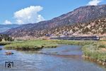 Der 'Rio Grande Zephyr' war ein Personenzug, der von der Denver and Rio Grande Western Railroad (D&RGW oder Rio Grande) zwischen Denver, Colorado und Ogden, Utah von 1970 bis 1983 betrieben wurde. Er war der letzte privat betriebene Fernreisezug in den Vereinigten Staaten. Der Zug war ein Überbleibsel des ursprünglichen 'California Zephyr', der von der Denver and Rio Grande Western Railroad und der Western Pacific Railroad betrieben wurde. Diese Version des Zephyr stellte ihren Betrieb am 22. März 1970 ein. Der 'Rio Grande Zephyr' nahm seinen Betrieb auf der Strecke des 'California Zephyr' auf, die Strecke wurde bis Ogden (Utah) verlängert, um Fahrgästen mit Ziel Kalifornien Anschluss an den 'San Francisco Zephyr' zu ermöglichen, der Salt Lake City nicht bediente. Der 'Rio Grande Zephyr' nutzte größtenteils dasselbe Fahrzeugmaterial und Personal wie zuvor der 'California Zephyr'. Da der Zug nicht mehr über Nacht fuhr, waren Schlafwagen und ein vollständiger Gepäckwagen nicht mehr erforderlich. Am 24. April 1983 wurde die Verbindung eingestellt. Der 'Rio Grande Zephyr' ist hier mit einer EMD F9 als Zuglok, dem dahinter laufenden Generatorwagen sowie den vier Aussichtswagen 'Silver Pony', 'Silver Colt', 'Silver Mustang' und dem Aussichtsplattformwagen "Silver Sky" bei Yarmony im Tal des Colorado River unterwegs. (09.08.1979) <i>Foto: Alan W. Clum</i>