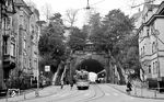 Eine Straßenbahn der Linie 8 zur Schreiberstraße am 125 m langen Schwabtunnel, erbaut zwischen 1894 und 1896. 1972 wurde die Linie 8 von der Buslinie 42 abgelöst, die bis heute durch den Tunnel verkehrt. Der Straßenbahnbetrieb durch den Schwabtunnel wurde damals eingestellt. Der Tunnel unterquert den Hasenberg und damit sowohl die Wannenstraße als auch die Hasenbergsteige. Er verbindet die Schwabstraße im Stuttgarter Westen mit der Schickhardtstraße im Stuttgarter Süden. Einst nur für Pferdefuhrwerke, Fußgänger und Straßenbahn geplant, nutzen den Tunnel heute täglich bis 20.000 Kraftfahrzeuge. Erschütterung, Abgase und im Winter eingetragenes salzhaltiges Spritzwasser greifen die Bausubstanz an, weshalb der denkmalgeschützte Tunnel 2019–2021 saniert wurde. 2025 wurde die Höchstgeschwindigkeit auf 30 km/h herabgesetzt, zudem gibt es einen Vorschlag, den Tunnel wieder auf nicht-motorisierten Verkehr zu beschränken. (19.12.1971) <i>Foto: Burkhard Wollny</i>