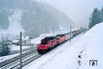 Im einsetzenden Schneetreiben ist bei Steinach in Tirol der zum Brenner fahrendende Sgk 42163 "Rollende Landstraße" mit ÖBB 1020.005 (ex E 94 030) und einer 1044 unterwegs. Nachdem der Schneefall immer heftiger wurde, wurde die Fototour hier abgebrochen. Schließlich musste man von hier noch zurück nach Mittenwald und wollte keine Übernachtung im eingeschneiten Auto riskieren. (19.02.1988) <i>Foto: Joachim Bügel</i>