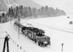 194 092 (Bw Ingolstadt) mit einem Regionalzug kurz vor Reutte in Tirol. Solche Winter stellten für die damalige Bahn kein Problem dar, bestanden die Züge statt aus Leichtbautriebwagen noch aus Wagen, die von schweren Lokomotiven gezogen wurden, wie der rund 120 t schweren E 94, die jede Spurille freifahren konnte. (03.01.1985) <i>Foto: Joachim Schmidt</i>
