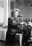 Eine Angestellte der Fka Augsburg Hbf am AEG-Fahrkartendrucker. Die Firma AEG baute bereits ab 1929 Fahrkartendrucker in verschiedenen Größen. Die sog. Klischee-Drucker mit Reihenregister wie z.B. der Typ AEG TIV-200 wurden vor dem 2. Weltkrieg auf fast allen Bahnhöfen der Deutschen Reichsbahn eingesetzt. (01.02.1943) <i>Foto: RBD Augsburg</i>
