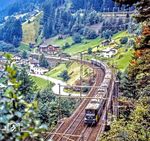 SBB Ae 8/14 11801 mit einem Sonderzug auf dem mittleren Teil der 360° Kehre bei Wassen. Die Ae 8/14 gab es in drei unterschiedlichen Ausführungen mit den Betriebsnummern 11801, 11851 und 11852. Alle wurden als Doppellokomotiven mit jeweils acht Trieb- und sechs Laufachsen pro Lok gebaut. Das Fahrwerk wurde für 100 km/h ausgelegt, damit die Lokomotiven auch im Reisezugverkehr eingesetzt werden konnten.  (15.09.1981) <i>Foto: Karsten Risch</i>