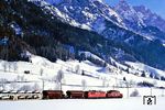ÖBB 1020.013 und 1110.027 rollen mit dem Dg 44973 vor den schneebedeckten Leoganger Steinbergen bei Hochfilzen auf Saalfelden zu. (23.02.1988) <i>Foto: Joachim Bügel</i>