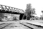 Eine unbekannte 03 fährt mit einem Schnellzug in Richtung Kohlenz durch den Bahnhof Brohl. Über die Brücke führt die Strecke der Brohltalbahn zum Rheinhafen. (1950) <i>Foto: Ernst Winter</i>