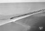 Einige Eisenbahnfreunde nutzten schon in Zeiten, in denen "Drohne" noch ein Fremdwort war, die Vogelperspektive für Fotos auf dem Hindenburgdamm. Hierzu konnte ein Sportflugzeug auf dem nahen Flughafen in Westerland (Sylt) gemietet werden. Allerdings gehörte schon eine Portion Überredungskunst dazu, den Piloten vom Überflug über den Hindenburgdamm zu überzeugen, weil dies schon damals nicht gerne gesehen war. Eine unbekannte 012 räuchert mit dem D 820 seinem Ziel in Westerland (Sylt) entgegen. (09.1971) <i>Foto: Ulrich Hesse</i>