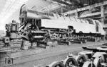 Im Gegensatz zur ersten Lokomotive besaß die 1939 gebaute 61 002 aus Gründen des besseren Massenausgleichs und der aufgrund der gleichmäßigeren Drehmomententwicklung besseren Anfahrzugkraft ein Dreizylinder-Triebwerk. Auch versah man diese Maschine mit größeren Vorratsbehältern für Wasser und Kohle, die zur Einhaltung der vorgesehenen maximalen Radsatzfahrmasse von 18,5 t den Einsatz eines dreiachsigen Drehgestells als hinteres Laufdrehgestell erforderten. Durch das leistungsfähigere Triebwerk sollte die Pünktlichkeit des Henschel-Wegmann-Zuges verbessert werden, die mit der 61 001 nicht immer befriedigend war. Das Bild zeigt die im Bau befindliche 61 002 in einer Werkhalle der Firma Henschel & Sohn in Kassel. (1939) <i>Foto: Werkfoto</i>