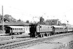 E 16 01 verlässt mit einem Schnellzug einen unbekannten Bahnhof in Oberbayern. Der Wagen hinter der Lok ist ein ehemaliger Rheingoldwagen nach Zeichnung SB4ük-28 oder -29 mit besetzter Küche. Links steht kein 'normaler' Personenwagen, sondern ein EBA 177 (Beiwagen für Akkumulatorentriebwagen). (08.1952) <i>Foto: Ernst Winter</i>