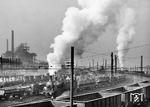 Ein Kübelwagenzug mit zwei Dampfloks auf der Werkbahn des Bochumer Vereins für Gußstahlfabrikation. Im Hintergrund sieht man die Hochofenanlage des Hüttenwerks. (1954) <i>Foto: BD Essen</i>