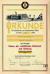 Mit diesen Urkunden wurden Arbeitsbereiche in der DDR geehrt, die als Musterbeispiele für sozialistische Arbeitsmoral, Disziplin und Sauberkeit galten. Die Verleihung diente der Förderung der „10 Gebote der sozialistischen Moral“ und war Teil der Bemühungen des SED-Regimes, Ordnung und Produktivität zu steigern. Im Januar 1975 erhielt der Schrankenposten B 1 im Bahnhof Tangermünde den Ehrentitel "Posten der vorbildlichen Sicherheit und Ordnung".  (01.1975) <i>Foto: Robin Garn</i>