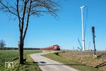 WLE Lok 51 passiert mit einem beladenen Steinzug eine Windradmontagebaustelle bei Anröchte. Die Lok (Typ G 1206) war 2002 bei Vossloh in Kiel gebaut und am 06.12.2002 an die Westfälische Landes-Eisenbahn (WLE) ausgeliefert worden. (02.03.2026) <i>Foto: Joachim Schmidt</i>