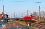 252 004 fährt mit dem beladenen Staubgutwagenzug von Spreewitz nach Naumburg durch den Bahnhof Mockrehna. Die Aufnahme entstand wenige Minuten vor Sonnenuntergang auf der östlichen Seite des Bahnhofs. Das links sichtbare Stellwerk "Mo" wurde 1910 in Betrieb genommen und ist mit einem Wärter besetzt. Der Fahrdienstleiter sitzt in einem Stellwerk im westlichen Bahnhofsbereich. (19.03.2026) <i>Foto: Ralf Opalka</i>