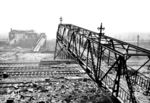 Die zerstörte Fußgängerbrücke mit Stellwerk "Ps" im Bahnhof Opladen. Im Vordergrund verlaufen die Gleise der Güterzugstrecke von Wedau nach Köln-Kalk Nord. Unter dem zerstörten Brückenteil die Strecke von Köln-Mülheim nach Wuppertal, hinter dem Stellwerk befindet sich das Gelände des RAW. (28.12.1944) <i>Foto: Karl Wolter</i>
