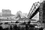 Die zerstörte Fußgängerbrücke, die die Werkstättenstraße am RAW mit der Opladener Innenstadt an der Wilhelmstraße (heute Friedrich-List-Straße) verband. Dazwischen liegen die Gleise der Güterzugstrecke Wedau—Köln-Kalk Nord. Bei dem Luftangriff Ende Dezmber 1944 wurden neben den Eisenbahnanlagen auch 167 Häuser vollständig zerstört, 317 Häuser schwer, 311 Häuser mittelschwer und 1739 Häuser leicht beschädigt.  (28.12.1944) <i>Foto: Karl Wolter</i>