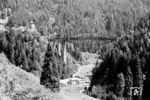 Eine ÖBB 1020 (E 94) überquert am Schloß Wiesberg die Trisanna zwischen Landeck und Strengen. 1883/84 wurde die ursprüngliche Brücke auf der Arlbergbahn nach einer Bauzeit von nur einem Jahr als größte Spannbogenbrücke Österreichs fertiggestellt. Steigende Achslasten führten dazu, dass die Trisannabrücke 1923 mit einem unten angeordneten sogenannten Fischbauchträger (Foto) verstärkt werden musste. 1964 wurde das Stahltragwerk durch eine Neukonstruktion ersetzt. (08.1957) <i>Foto: Jürgen Hagemann</i>