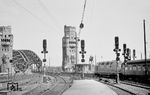 Eine unbekannte V 200 des Bw Hamm (Westf) verlässt mit D 103 (Köln - Hamburg-Altona) den Kölner Hauptbahnhof. Die Brückentürme wurden zwei Jahre später im Zusammenhang mit der anstehenden Elektrifizierung abgerissen. (06.1957) <i>Foto: Ernst Winter</i>