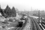 Blick vom Rubertussteg in Höhe des Bahnbetriebwerks auf E 60 08, die gerade einen Güterzug über den Ablaufberg im Bahnhof Freilassing drückt. Daneben verläuft das Streckengleis nach Mühldorf (Oberbay). (02.1968) <i>Foto: Jürgen Hagemann</i>