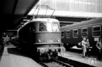Bis auf einen kurzen Ausflug von zwei Jahren nach Hagen war E 19 01 von 1939 bis 1977 immer beim Bw Nürnberg Hbf stationiert. Hier rollt sie aus der Halle in München Hbf. Rechts übernimmt gerade der Reinigungstrupp den D 204 aus Dortmund. (11.08.1965) <i>Foto: Reinhard Gumbert</i>