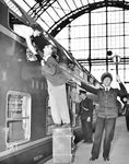 Wohl nicht ganz Ernst gemeint war dieses gestellte Pressefoto an dem neuen Doppelstockzug E 719 nach Dortmund in Frankfurt (M) Hbf, zumal der Aufsichtsbeamte den Abfahrauftrag in die falsche Richtung gibt. Der Pressetext hebt einerseits das neue komfortable Reisen in den Doppelstockwagen hervor, weist aber auch augenzwinkernd darauf hin, dass der Abschied von der Liebsten nun doch deutlich schwerer ist. (28.07.1951) <i>Foto: ACME Hans Jäger</i>
