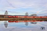 Auch für den RE 4857 nach München mit 218 423 gelang eine fast perfekte Spiegelung in den Wiesauer Fischteichen. (09.04.2026) <i>Foto: Joachim Bügel</i>