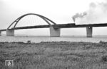 018 323 bei der Überfahrt über die Fehmarnsundbrücke. Die Brücke verbindet die Ostsee-Insel Fehmarn mit dem Festland bei Großenbrode. Nach der Eröffnung im Jahr 1963 konnte die durchschnittliche Reisezeit auf der sogenannten Vogelfluglinie von Hamburg nach Kopenhagen deutlich verkürzt werden. Das Landesamt für Denkmalpflege Schleswig-Holstein stellte die Fehmarnsundbrücke 1999 unter Denkmalschutz. (24.08.1969) <i>Foto: Jürgen Hagemann</i>