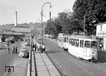 Tw 118 mit Bw 165 auf der Linie 2 am Kranenkai vor der Friedensbrücke und dem Heizkraftwerk. Noch immer stand Anfang der 1960er Jahre der Ersatz der Straßenbahn durch einen (Oberleitungs-)Omnibus zur Diskussion, denn der damalige Hauptaktionär, die Energiewirtschaft Mannheim, aber auch die Stadt Würzburg, zeigten wenig Interesse am Weiterleben der vielerorts aussterbenden Fortbewegungsmittel auf Schienen. Der Reifenverschleiß der Busse in anderen Städten war aber wegen nachkriegsbedingter schlechter Materialien so heftig, dass der Bus für Würzburg dann doch ad acta gelegt wurde. (10.1961) <i>Foto: Reinhard Todt</i>