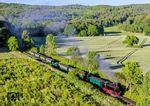 99 1781 mit P 232 nach Putbus in der Steigung vor Garfitz. Als besonderes Schmakerl setzt die RüBB in den Sommermonaten offene Aussichtswagen ein, die bei den Fahrgästen sehr beliebt sind. (28.05.2026) <i>Foto: Joachim Schmidt</i>