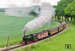 Sechs Wagen der RüBB erhielten ihre ursprünglich braune Farbgebung und die alte Rü.K.B.-Nummern zurück. Für diesen einmaligen Zug wurde schon Mitte der 1980er Jahre der Grundstein gelegt. Einige Fahrzeuge stellte man sogar unter Denkmalschutz. Dazu zählen die Wagen 28 (Gepäckwagen), 29 (Speisewagen), 33, 34 und 37. Bei Beuchow befördert Lok 53 Mh den Zug. Die Lok wurde 1925 unter dieser Nummer an die Rügensche Kleinbahnen AG, Putbus (Rügen) ausgeliefert. Während der Reichsbahnzeit lief sie unter der Nummer 99 4633. (31.05.2026) <i>Foto: Joachim Schmidt</i>