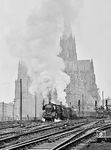 Damals Alltag in Köln: 03 179 (Bw Köln Bbf) leistet einer P 8 Vorspann vor einem Schnellzug, der im Schatten des Doms zur Hohenzollernbrücke ausfährt. (27.09.1958) <i>Foto: Ernst Winter</i>